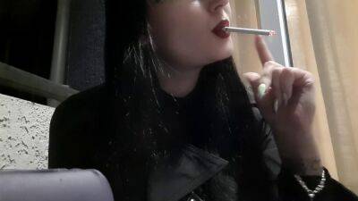 Dominatrix Nika smokes a cigarette on the balcony. Mistress sexy red lips blow smoke in your face - sunporno.com